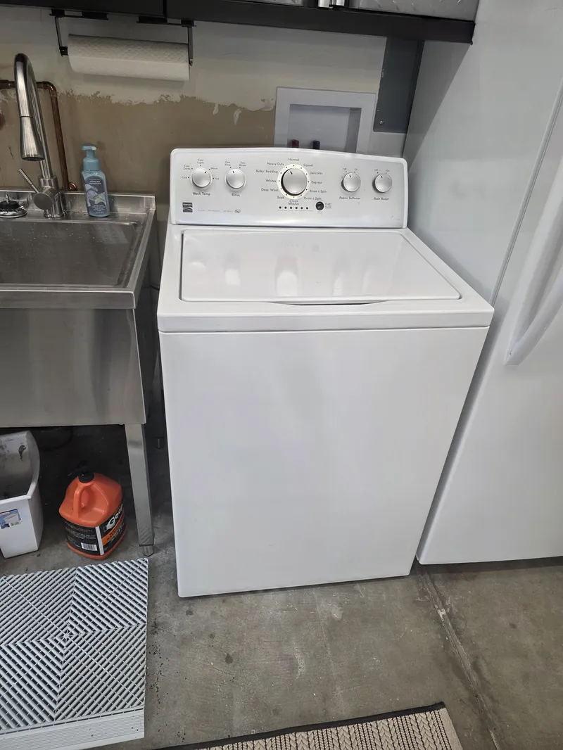 Kenmore top-load washer being serviced in a San Rafael garage laundry area