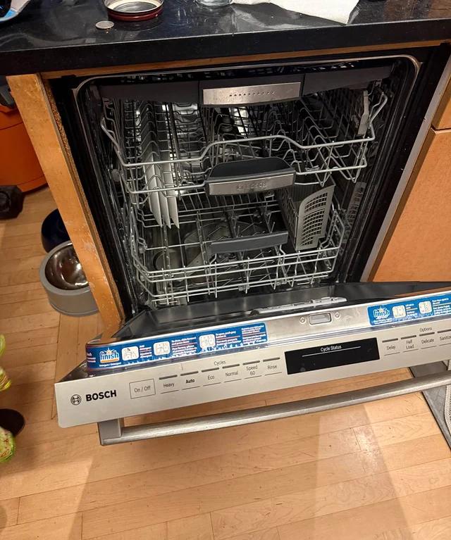 Bosch dishwasher with the door open showing racks and control panel