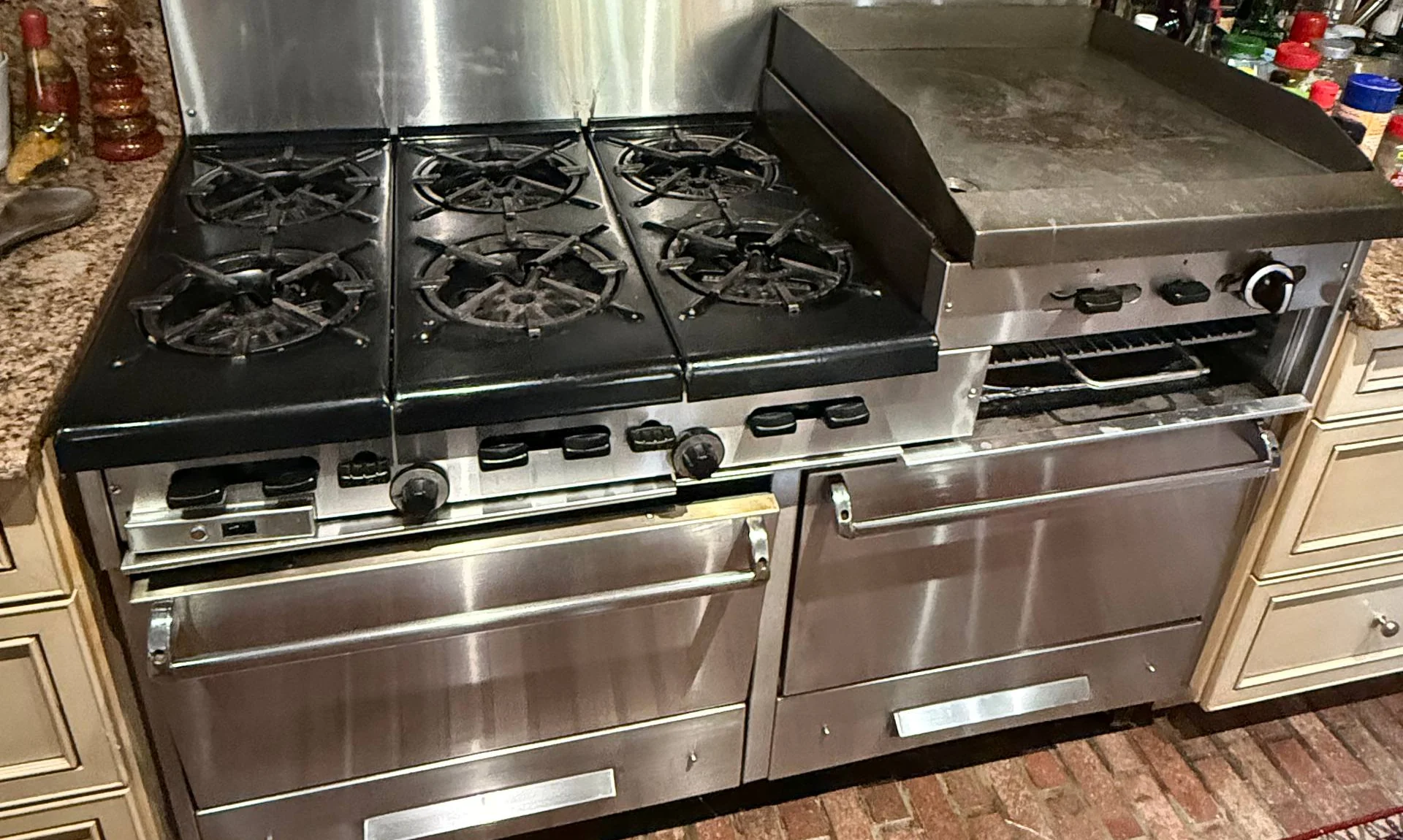 Large commercial-style stainless range with six burners, a griddle and two ovens