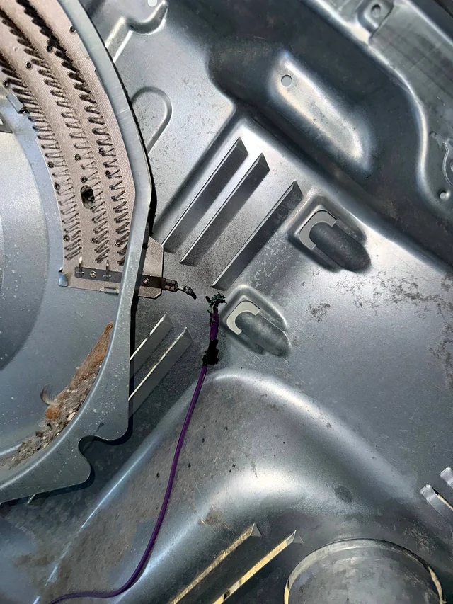 Dryer heating element coil with lint residue inside the dryer